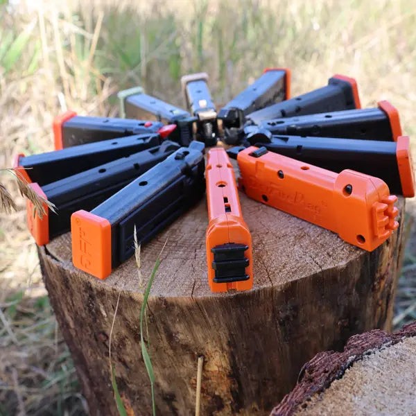 Family picture of trigger resetting Standard DryFireMags on a log